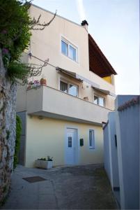 a large white building with a door in a driveway at Mea Mali Lošinj in Mali Lošinj