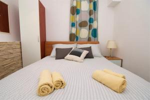 a bedroom with a white bed with towels on it at Mea Mali Lošinj in Mali Lošinj