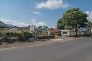 a street in a town with a fence and houses at RedDoorz @ Maribaya Street 2 in Bandung