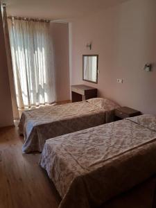 een hotelkamer met 2 bedden en een spiegel bij Apartment By The Sea in Pomorie