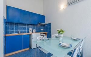 a blue kitchen with a table and blue cabinets at Maja Apartment 2 in Funtana +14 photos