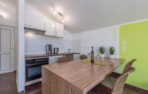 a kitchen with a wooden table and some chairs at Maja Apartment 3 in Funtana +17 photos