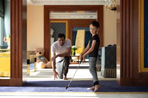 a man helping a young girl with a cane at Jumeirah Burj Al Arab Dubai in Dubai