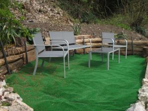 4 sillas y una mesa sobre césped verde en L'Inattendue, en Chaumont