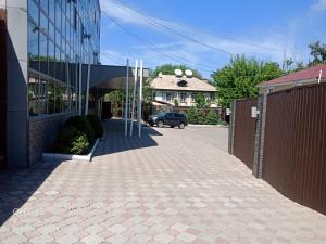 a building with a car parked next to a driveway at Janblue Hotel in Almaty