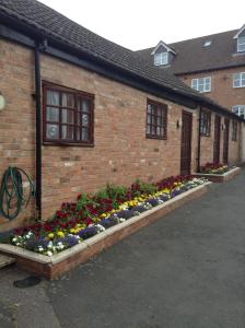 Un edificio de ladrillo con un ramo de flores. en The Black Horse Inn, en Warwick