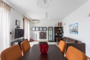 a dining room with a black table and orange chairs at Sunrise Apartment Venice in Marghera