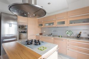 a large kitchen with wooden cabinets and a stove at Sunrise Apartment Venice in Marghera