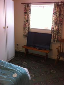 sala de estar con TV de pantalla plana sobre una mesa en The Black Horse Inn en Warwick