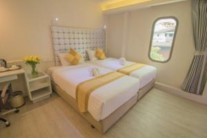 sypialnia z 2 łóżkami i oknem w obiekcie Justice Hotel w mieście Bangkok