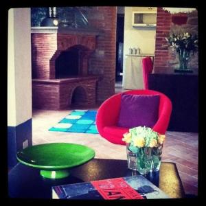 a living room with a red chair and a table at Crocino (appartamento al piano superiore) in Loro Ciuffenna