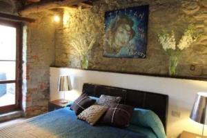 1 dormitorio con 1 cama y una pintura en la pared en Crocino (appartamento al piano superiore), en Loro Ciuffenna