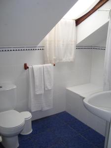 a white bathroom with a toilet and a sink at Hosteria Peña Sagra in Ojedo