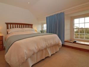 a bedroom with a large bed and a window at Halvosso in Penryn