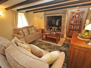 sala de estar con sofá y chimenea en Nanparra Cottage, en Falmouth