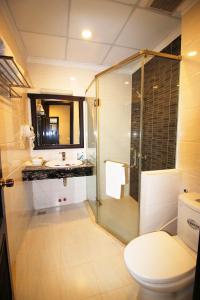 uma casa de banho com um chuveiro, um WC e um lavatório. em Royal Dalat Hotel em Da Lat