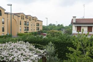 a garden with white flowers in front of buildings at Sunrise Apartment Venice in Marghera