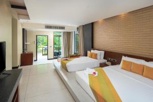 a hotel room with two beds and a television at The Zign Hotel Premium Villa in North Pattaya