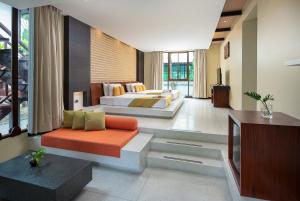 a living room with two beds and a tv at The Zign Hotel Premium Villa in North Pattaya