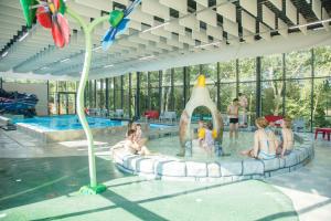 a group of people sitting in the water in a swimming pool at Dormio Resort Maastricht in Maastricht