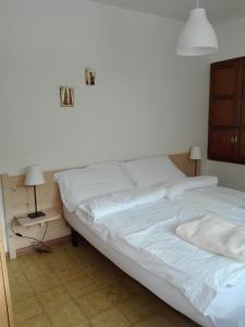 a bedroom with a white bed and a night stand at Casa Simion in Mezzano