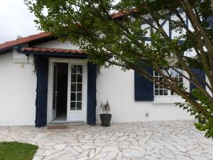 una casa blanca con una puerta azul en Charmant T2 bord de mer, en Anglet
