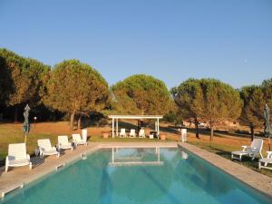 a swimming pool with chairs and a gazebo at Agriturismo Podere Borgognano in Massa Marittima