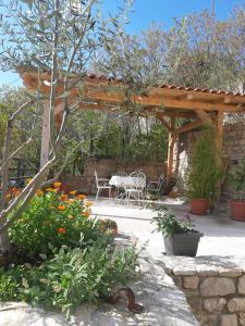 a patio with a table and chairs under a wooden pergola at Holiday Home Anna in Skradin