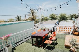 a patio with a wooden table and chairs on a roof at Nai's house - Homestay in Thanh Hải