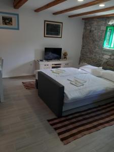 a bedroom with a large bed and a tv at Holiday Home Anna in Skradin