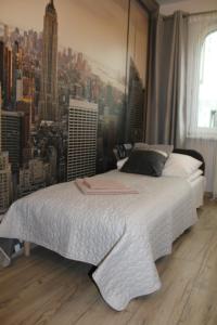 a bedroom with a large bed with a city skyline at Apartamenty przy Starym Rynku in Poznań