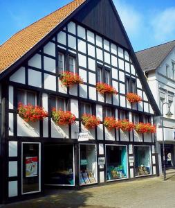 a black and white building with flowers in the windows at Ferienwohnung Sonnenschein in Lengerich