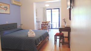 una camera con letto, scrivania e tavolo di Paraktio Beach Apartments a Kiotari