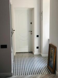 a hallway with a white door with a checkered floor at VIP apartment history in Lviv
