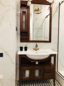 La salle de bains est pourvue d'un lavabo et d'un miroir. dans l'établissement VIP apartment history, à Lviv