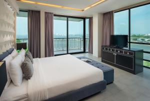 a bedroom with a large bed and a television at Way Hotel Pattaya in North Pattaya