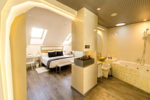 a bedroom with a bed and a bathroom with a tub at Hotel & Spa Princesa Munia in Oviedo