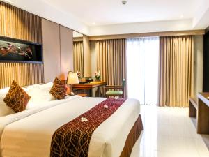 سرير أو أسرّة في غرفة في The Nest Hotel Nusa Dua