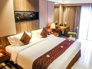 سرير أو أسرّة في غرفة في The Nest Hotel Nusa Dua
