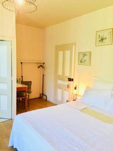 a bedroom with a large white bed and a desk at La maison d'Hera in Saint-Yrieix-la-Perche