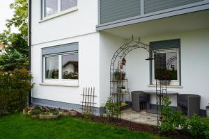 a white house with an archway on a patio at Ferienwohnung Zeilfelder in Hirschberg an der Bergstraße