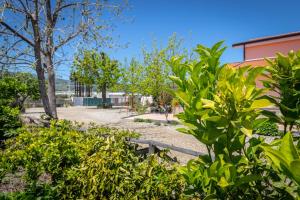 マスカリにあるIl Giardino country holiday with poolの樹木や茂みのある公園と建物