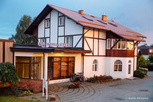 una gran casa blanca con techo rojo en Spa Hotel Ezeri, en Sigulda