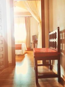Habitación con silla, cama y ventana en Hotel Hacienda del Cardenal en Toledo