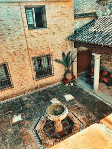 una fuente en el patio de un edificio de ladrillo en Hotel Hacienda del Cardenal en Toledo