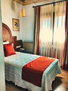 a bedroom with a large bed and a window at Hotel Hacienda del Cardenal in Toledo