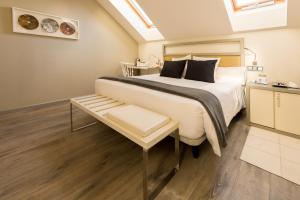 a bedroom with a large bed and a table at Hotel & Spa Princesa Munia in Oviedo