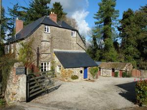 an old stone house with a gate in front of it at Maristow Barton in Plymouth