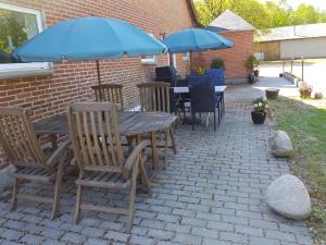 un patio con tavolo, sedie e ombrelloni di Kyndestoft Bed & Breakfast a Holstebro