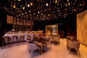 un restaurante con un bar con mesas y sillas en Kowloon Harbourfront Hotel, en Hong Kong